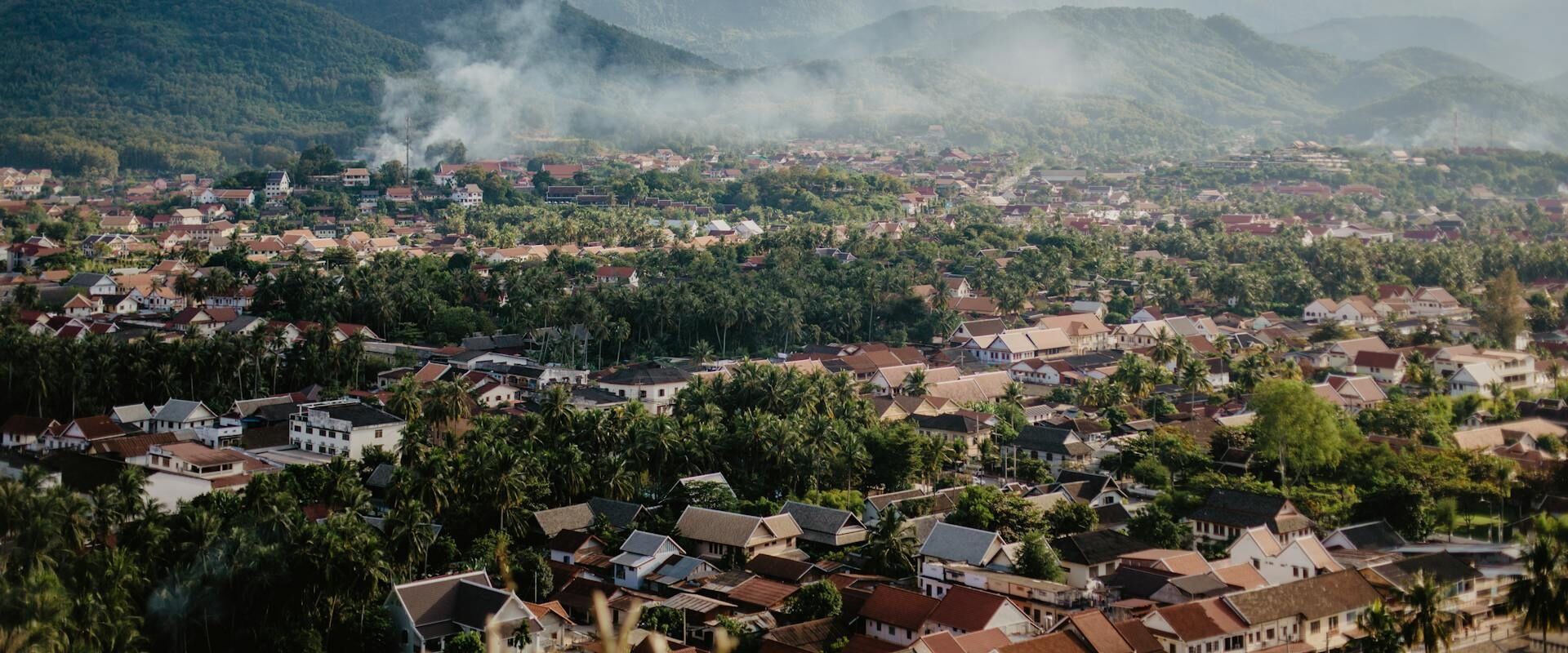 Luang Namtha’s tranquil countryside at sunset on a Luang Namtha Travel banner by Legend Travel Group.